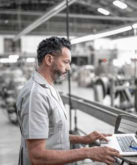 man standing looking at a laptop